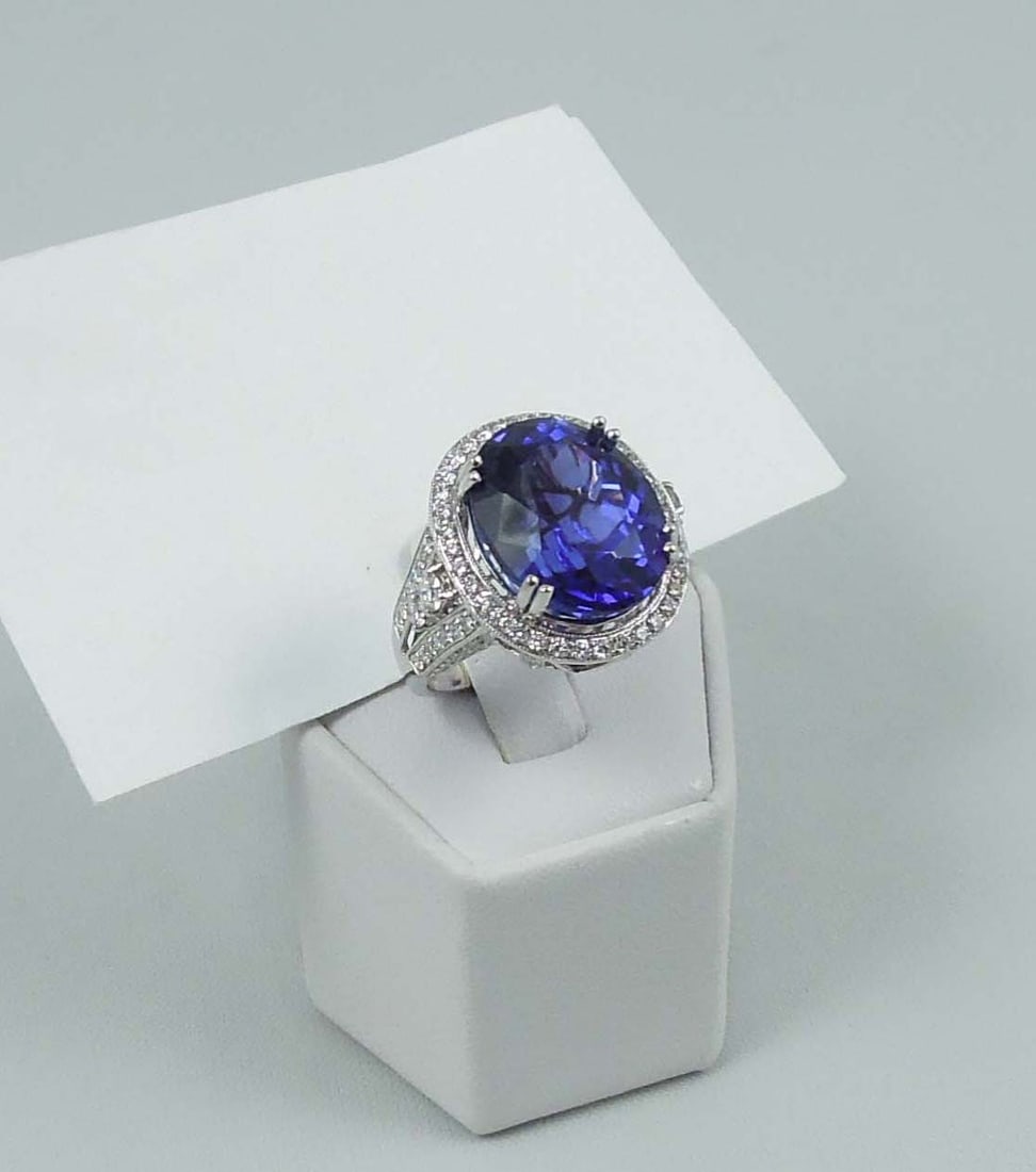 SPECTACULAR LADIES 18K W.G., TANZANITE & DIAMOND RING: A large white gold mount set with an oval cut tanzanite weighing approx. 18.19 cts. Excellent quality & intense violetish blue coloration. Ring completed with full cut round diamonds totaling 1.58 cts