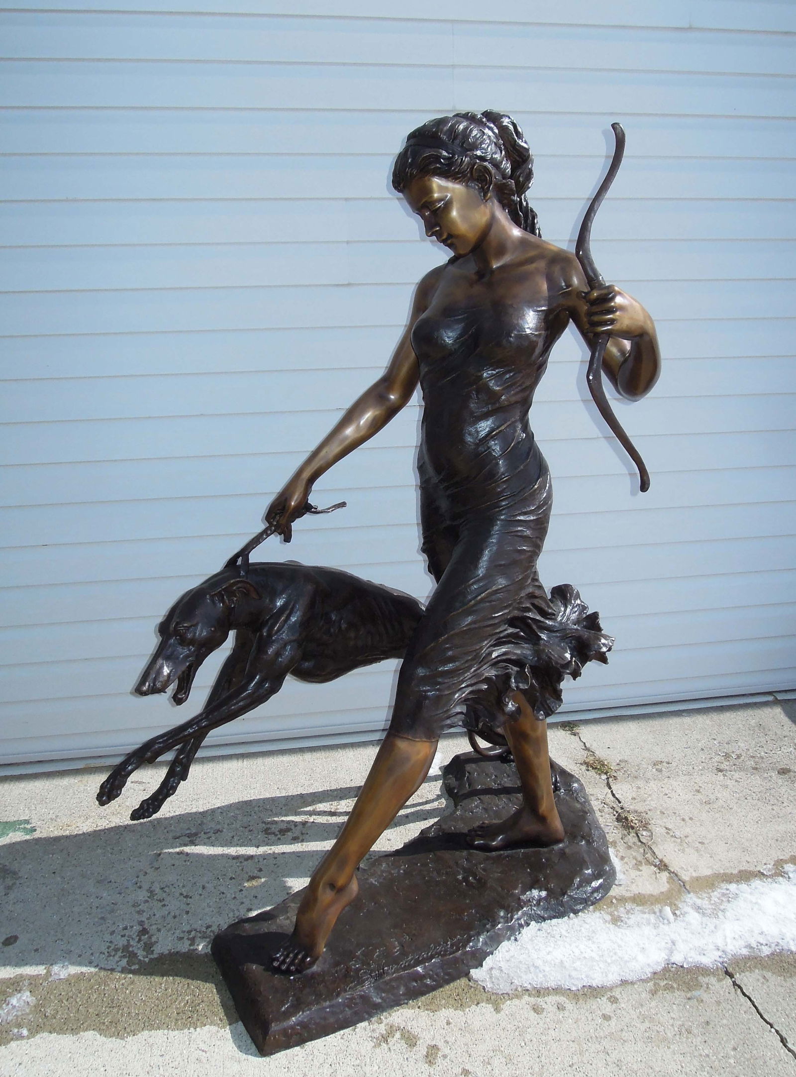 SPECTACULAR LIFE SIZE BRONZE SCULPTURE OF ARTEMIS (THE GODDESS OF THE HUNT & WILDERNESS) WITH DOG: Fabulous detail. Two color patina. Signed on base. 66" high, 31" wide, 46" deep.