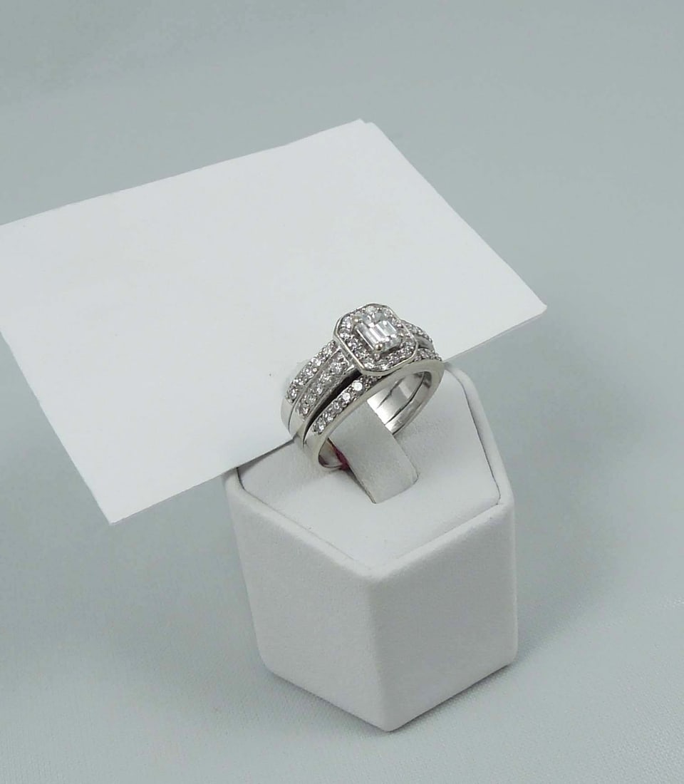 LADIES 14K W.G. AND DIAMOND RING: A wide white gold band set with a fine emerald cut diamond weighing approx. .40 ct. Band completed with rows of full cut round diamonds totaling approx. .75 ct. Ring weighs 10.3 grams.