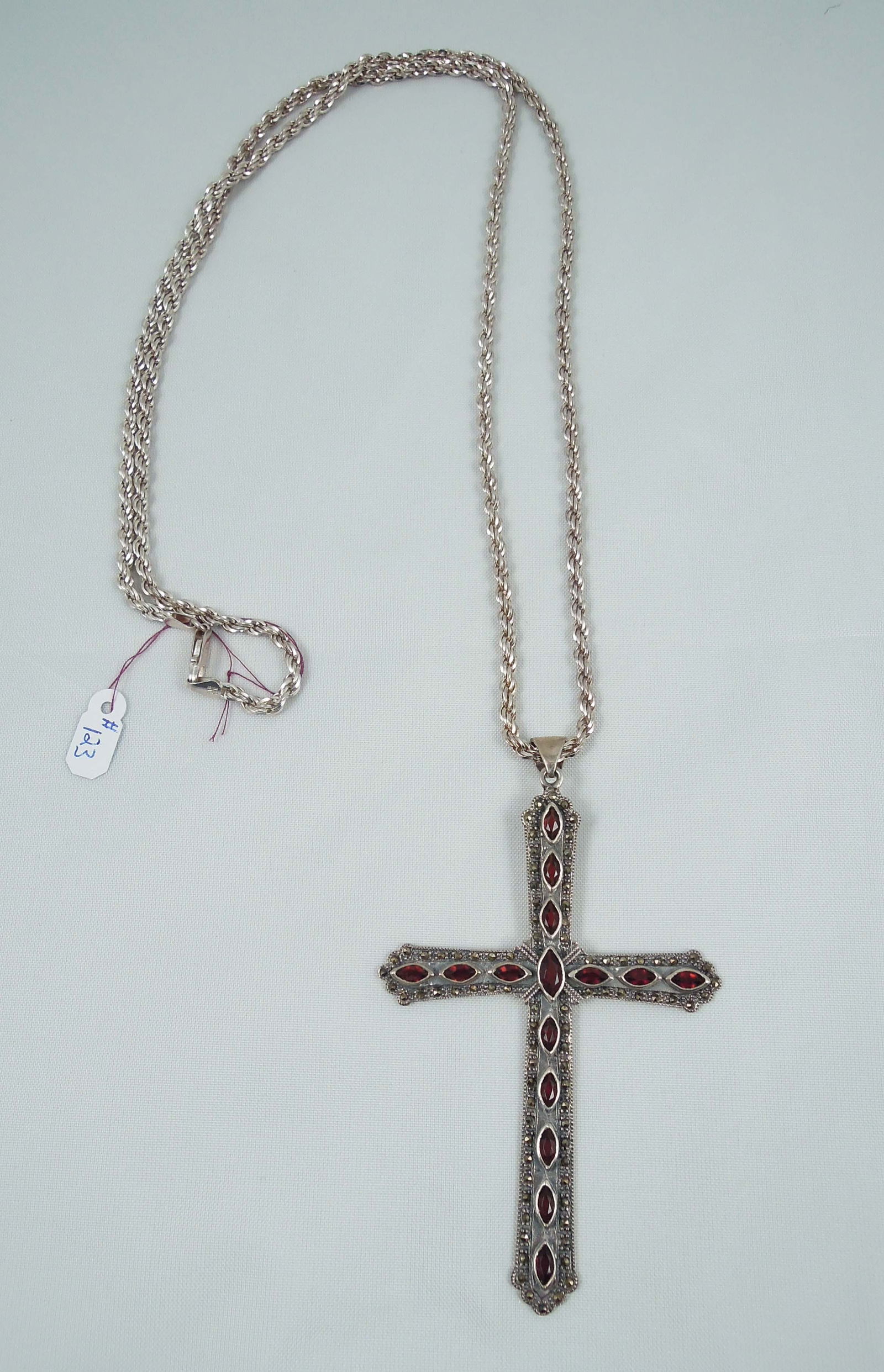 LADIES VINTAGE STERLING SILVER, GARNET & MARCASITE CROSS NECKLACE: A long heavy sterling chain supports a large vintage cross pendant set with marquise cut garnets and bordered by rows of marcasite. 60.7 grams. Chain 35" long. Total length with pendant 39".