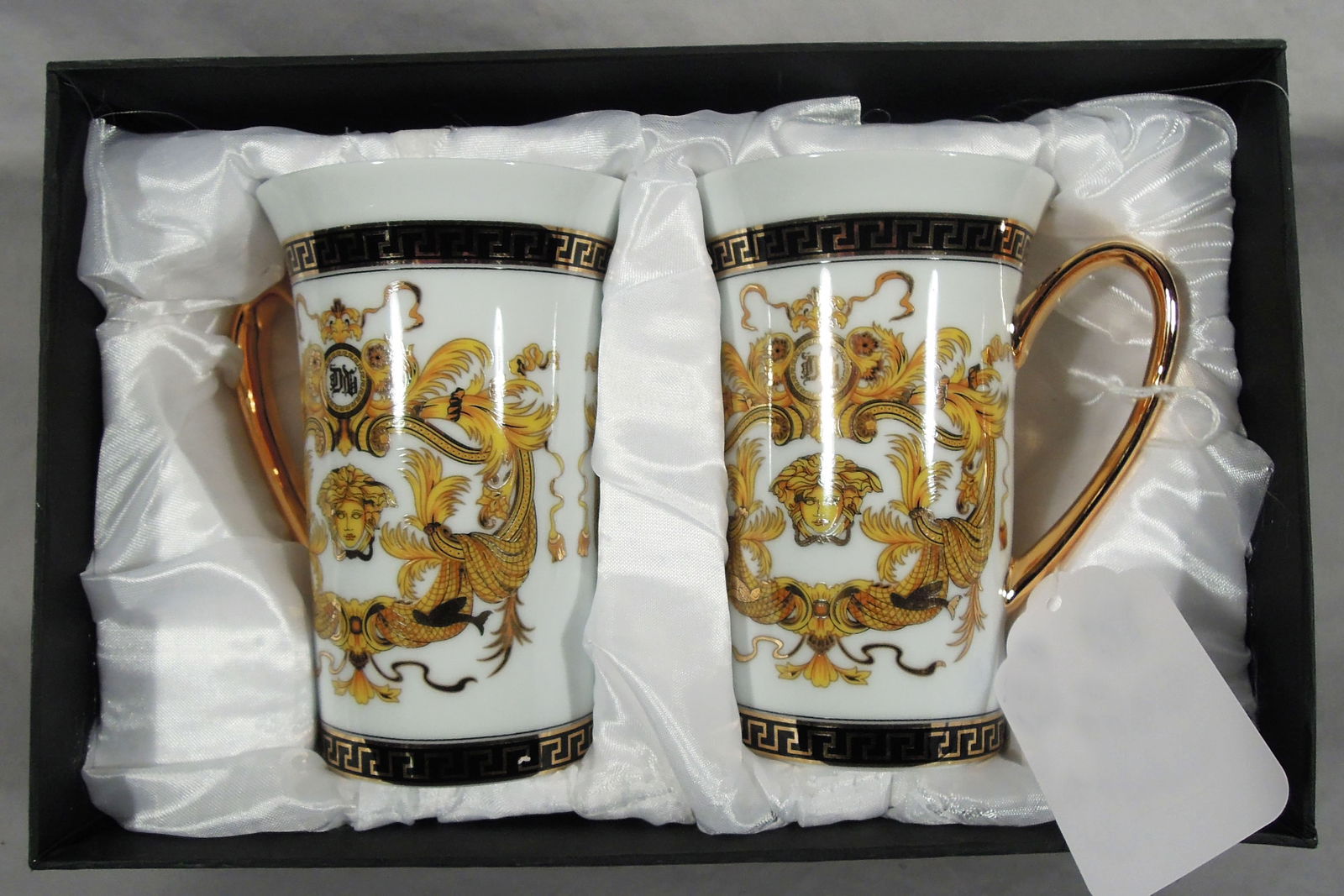 PAIR VERSACE STYLE COFFEE MUGS: "Medusa" and Greek key design. White ground. In original box.