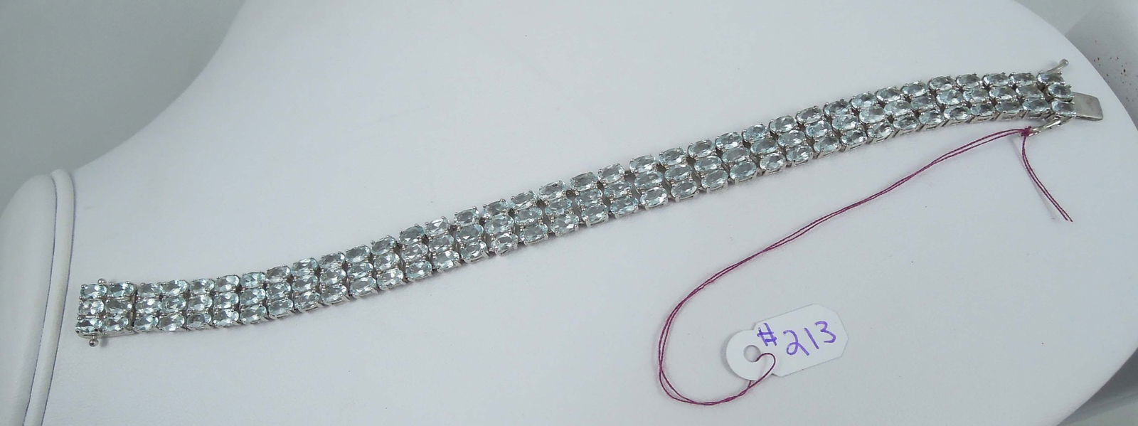 LADIES FINE STERLING SILVER & SYNTHETIC BLUE TOPAZ BRACELET: A wide bracelet with three rows of oval cut synthetic blue topaz. 7 1/2" long.