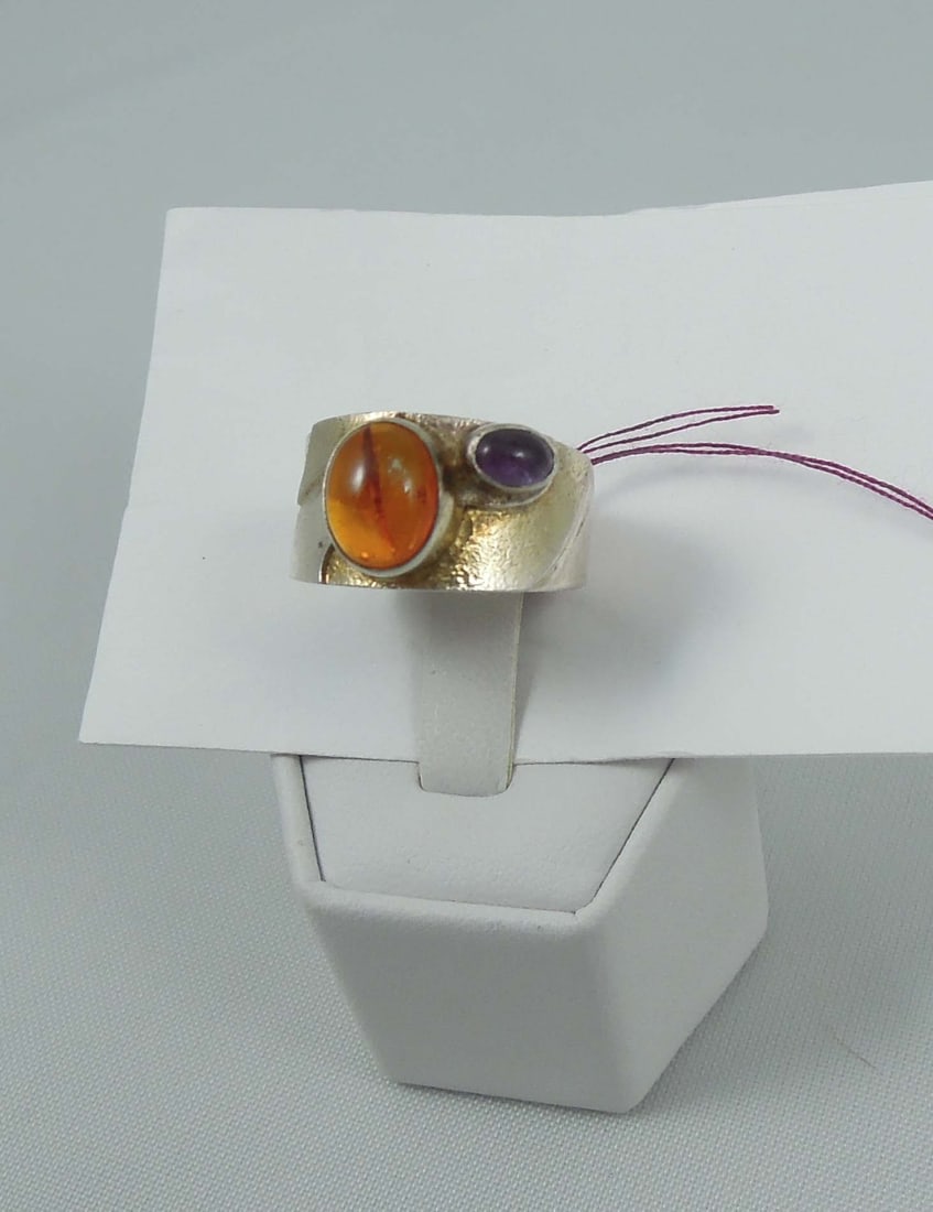 LADIES VINTAGE STERLING SILVER, AMBER AND AMETHYST RING: A wide sterling band set with a cabochon amber and cabochon amethyst. Size 7 1/4.