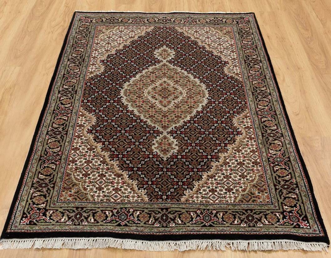 FINE HAND KNOTTED MAHI TABRIZ AREA RUG: Wool rug with black ground. Excellent condition. 4' x 6'.