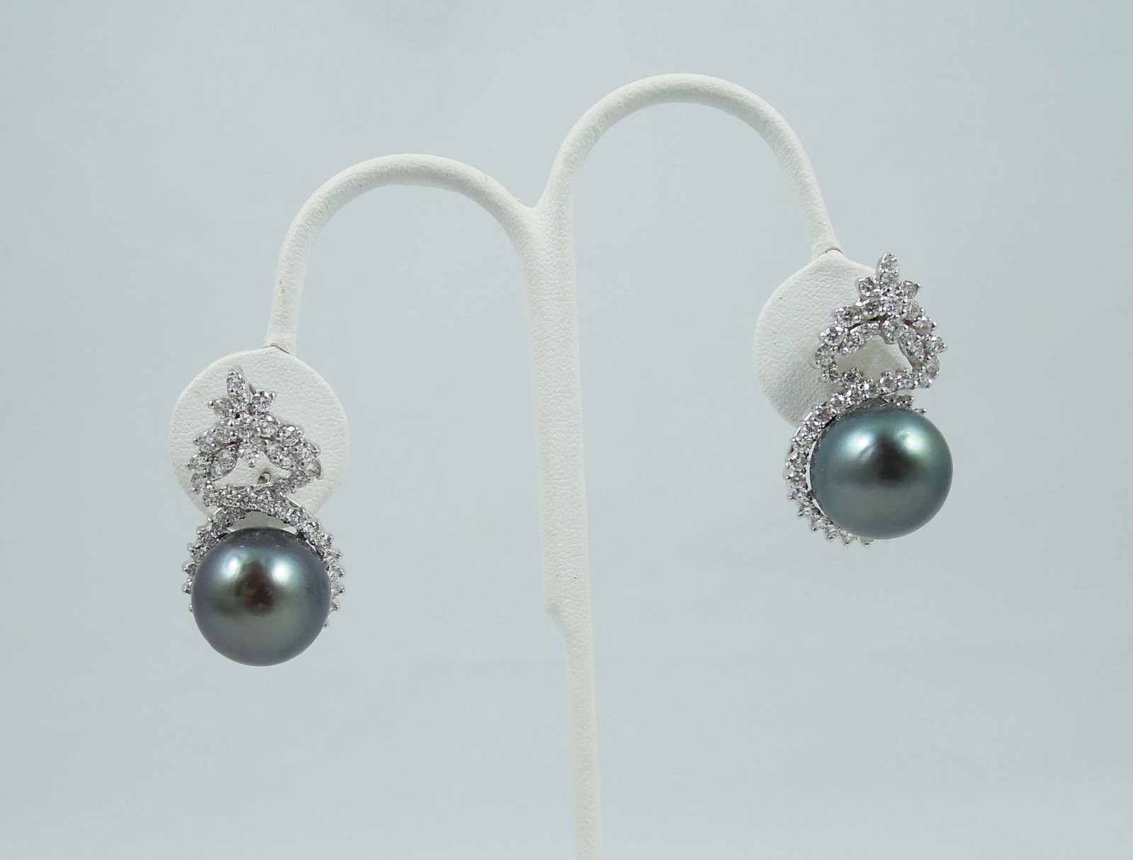 PAIR LADIES LARGE 14K W.G., DARK GREY SOUTH SEA PEARL & DIAMOND EARRINGS: Each earring set with a beautiful dark grey South Sea pearl (measuring 16-16 1/2mm). South sea pearls of high quality and ultra high lustre. Each earring completed with full cut round diamonds