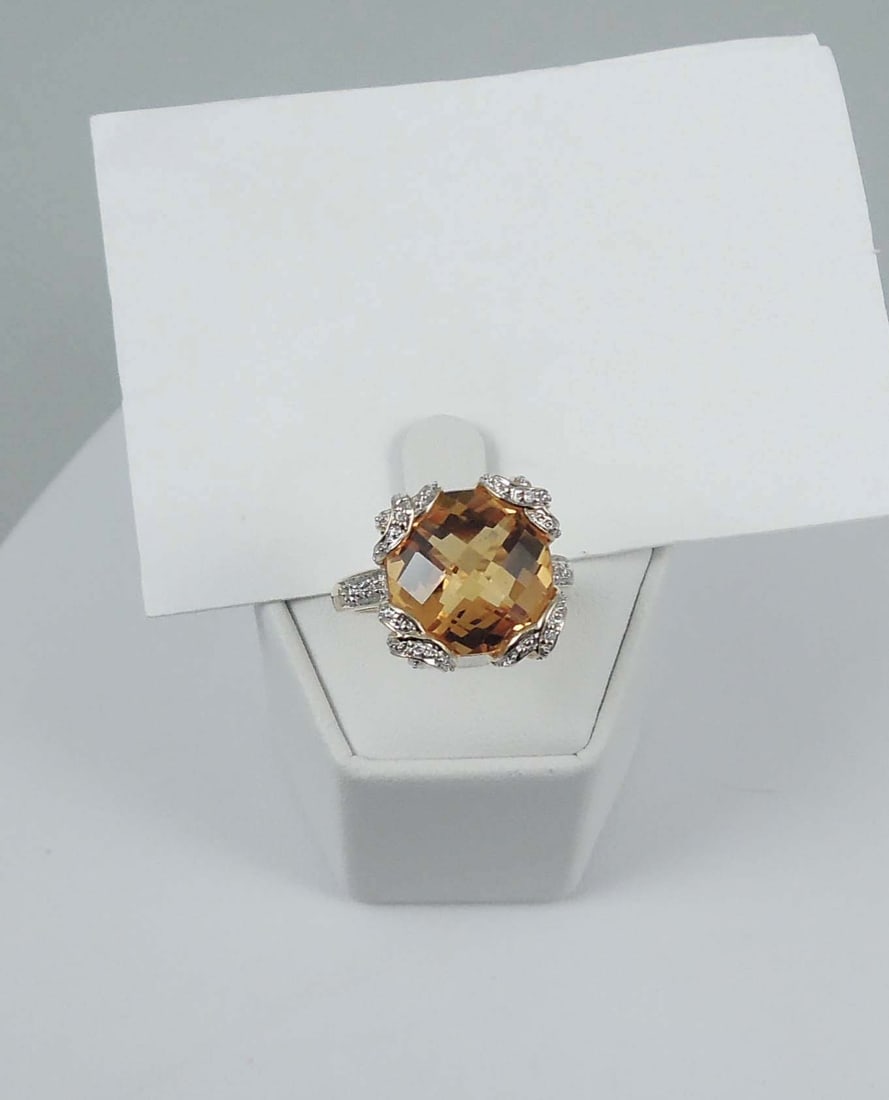 LADIES 14KY.G. & W.G., CITRINE & DIAMOND RING: A highly polished open work mount set with a beautiful heavily faceted cushion cut citrine weighing approx. 5 cts. Ring completed with approx. .15 ct. of full cut round diamonds.