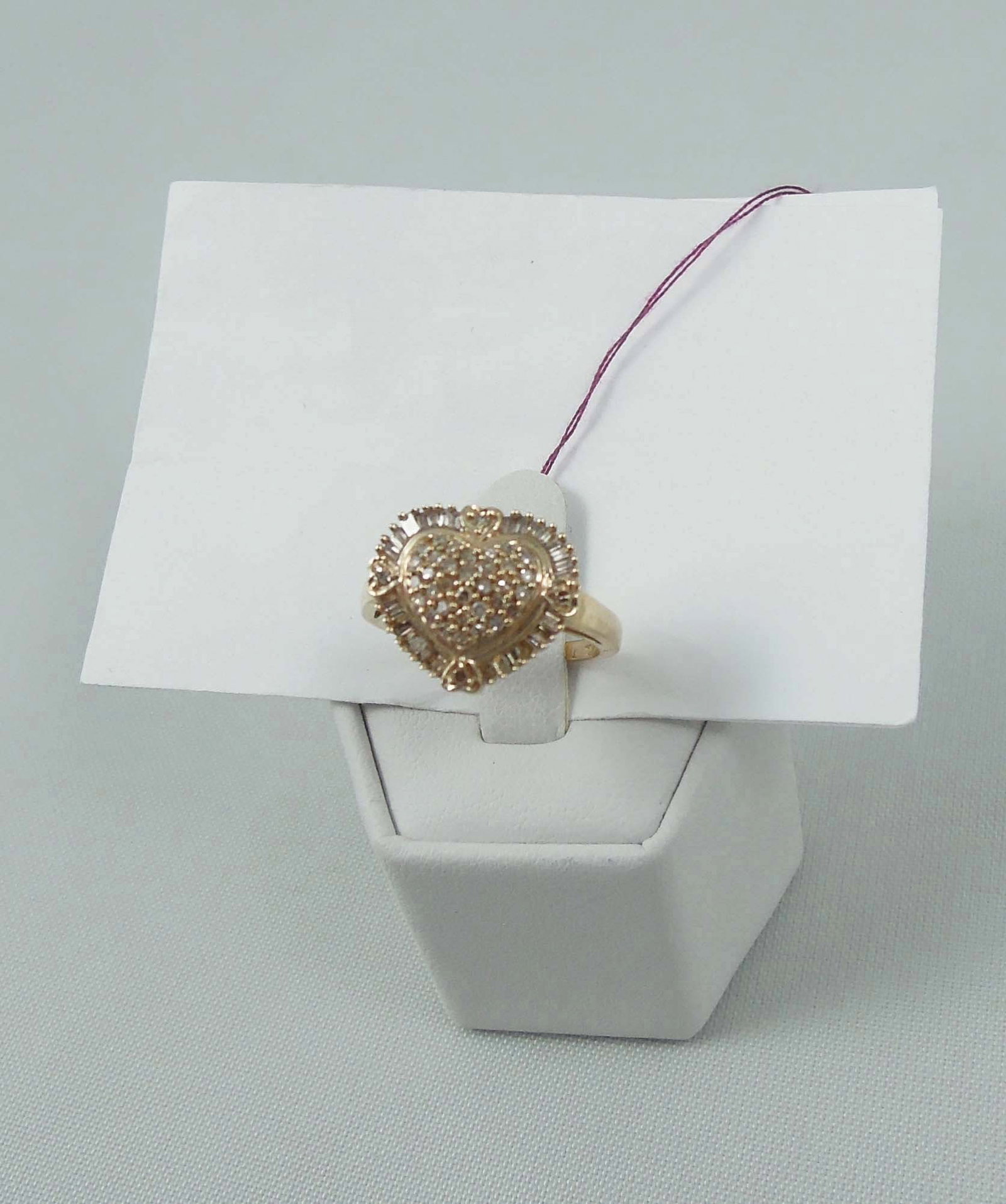 LADIES 10K Y.G. & DIAMOND HEART SHAPED RING: A highly polished mount with a center heart shaped section set with full cut round and baguette cut diamonds totaling approx. .50 ct.