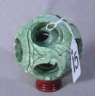UNUSUAL HAND CARVED CHINESE JADE BALL IN BALL: UNUSUAL HAND CARVED CHINESE JADE BALL IN BALL A graduated carved ball in ball. Fitted rosewood stand. 5" high, 5" dia.