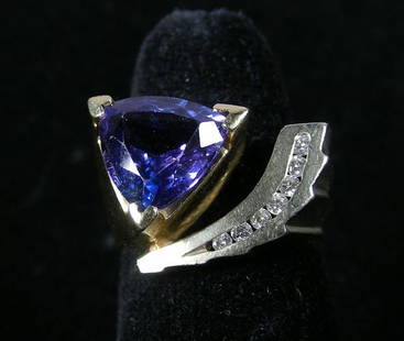 LADIES HEAVY 14K YELLOW AND WHITE GOLD, TANZANITE AND: LADIES HEAVY 14K YELLOW AND WHITE GOLD, TANZANITE AND DIAMOND RING A contemporary style yellow and white gold mount set with a heavily faceted trillion cut tanzanite weighing approx. 3 cts. Ring is