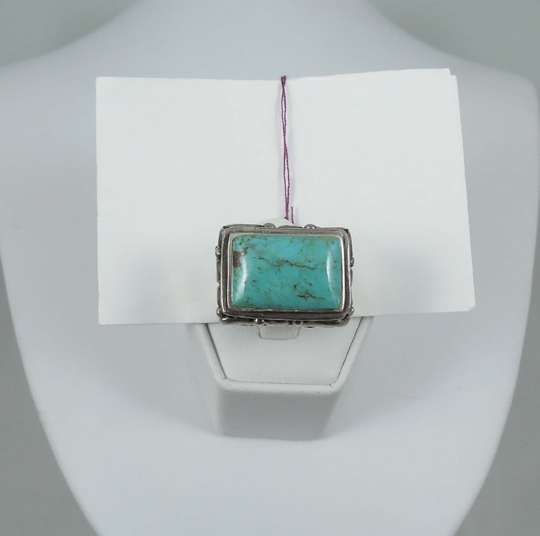 VINTAGE NATIVE AMERICAN STERLING SILVER & TURQUOISE RING: A heavy highly polished ring with elaborate border is set with a rectangular fine turquoise. 15.5 grams.