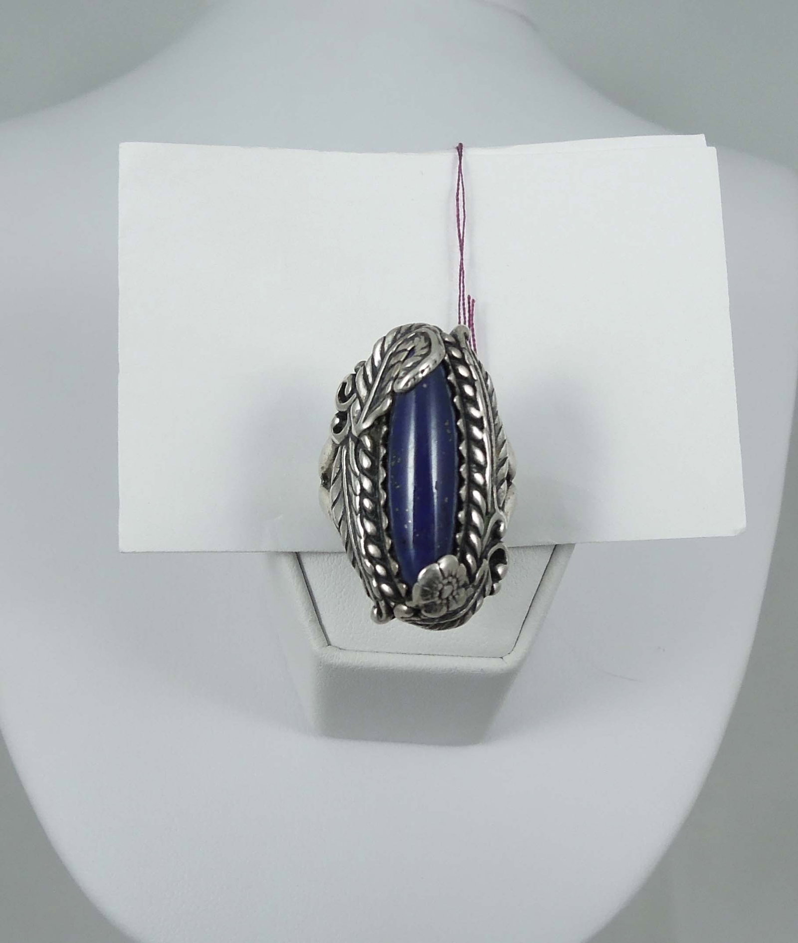 VINTAGE NATIVE AMERICAN STERLING SILVER AND LAPIS RING: A large sterling silver ring with feather motif is set with an oblong lapis. 12.1 grams.