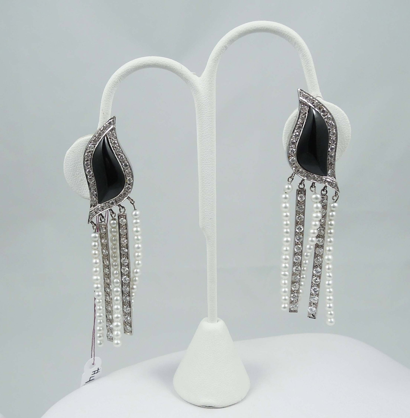 PAIR OF UNUSUAL CUSTOM MADE 14K W.G., BLACK ONYX, PEARL & DIAMOND DANGLE EARRINGS: An ususually shaped top with black onyx is surrounded by a single row of ful cut round diamonds. Top supports four dangles with seed pearls and full cut round diamonds. Total diamond weight approx. 2.