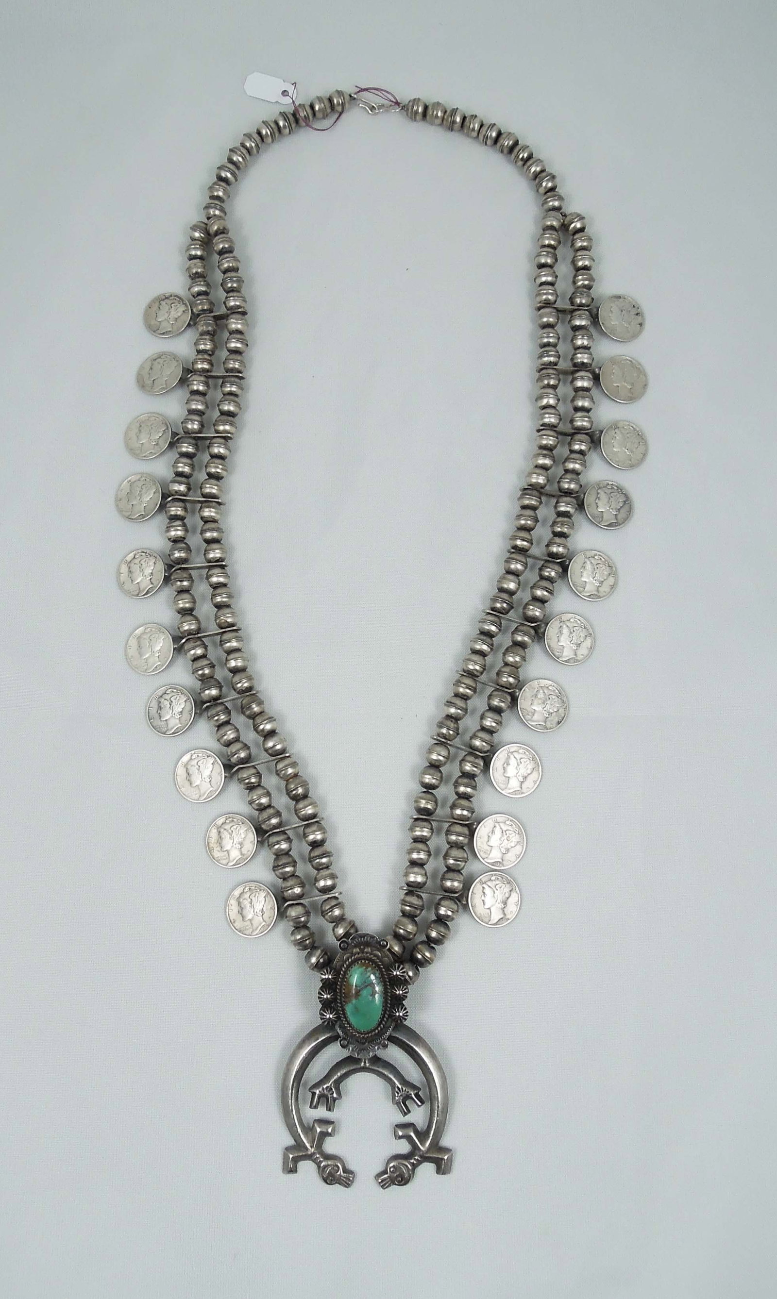 VINTAGE JIM RED FEATHER NAVAJO STERLING SILVER, TURQUOISE & MERCURY DIME SQUASH BLOSSOM: An Important Mercury dime squash blossom made by well known Chief Jim Redfeather (James Urban Brady, Navajo Sioux 1902-1987). Hallmarked JRF. Length approx. 28 1/2 not including naja.