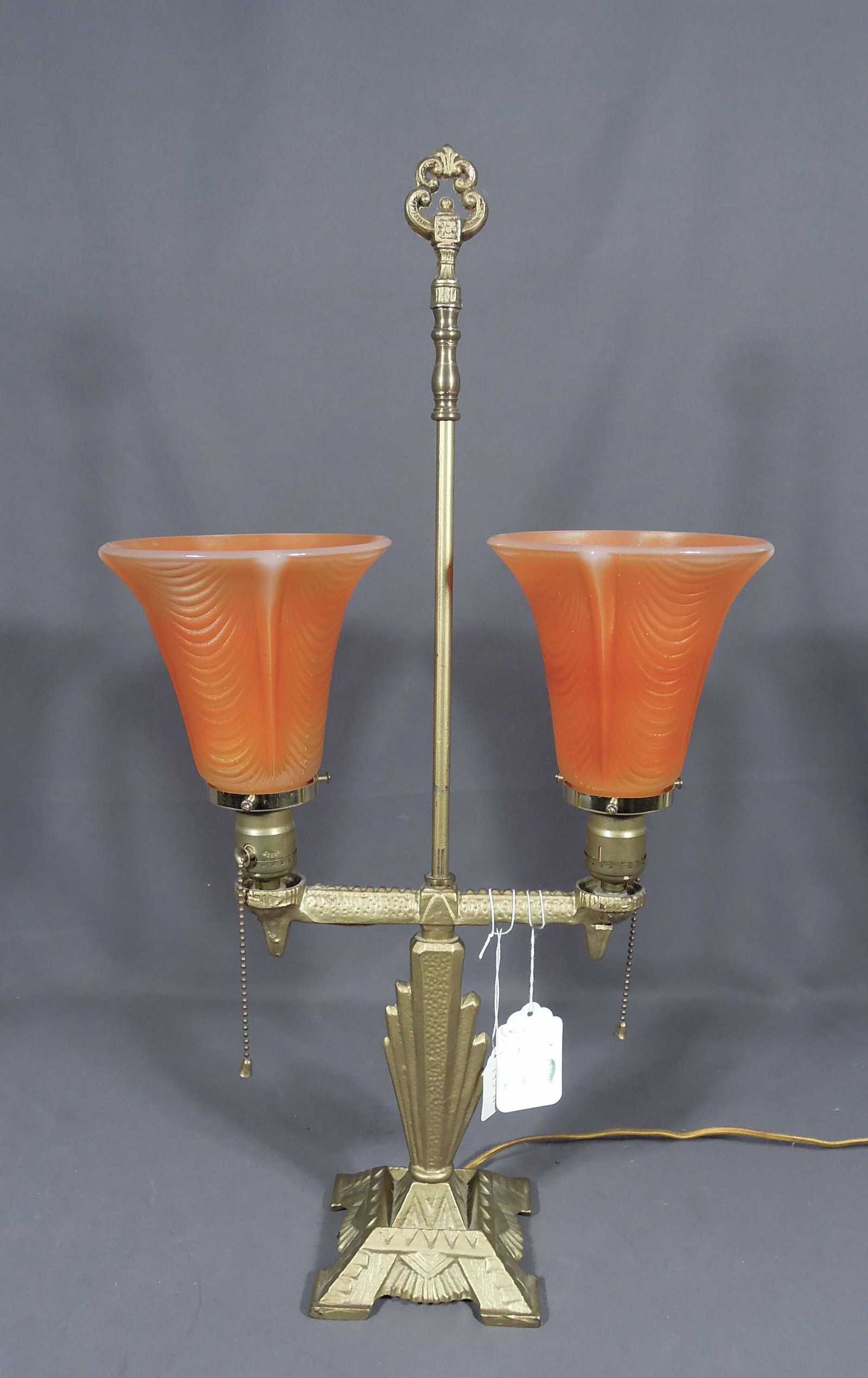 AUTHENTIC ART DECO GILT METAL AND ART GLASS TABLE LAMP: Peach colored shade. Very good condition. 25" high, 13" wide, 6" deep.