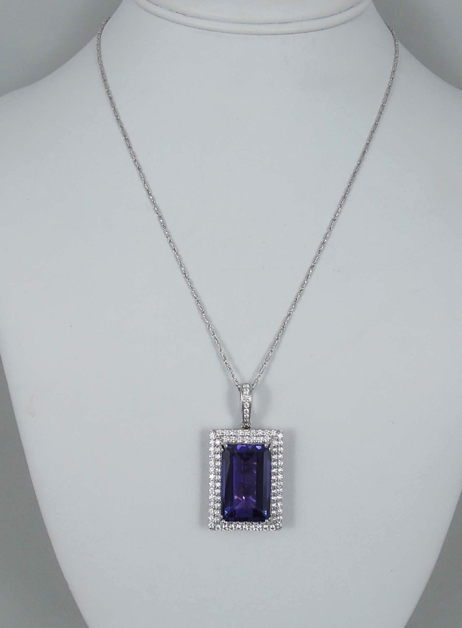 DESIGNER ORIANNE OUTSTANDING LADIES 18K W.G., TANZANITE & DIAMOND NECKLACE: An 18K necklace supports a rectangular shaped pendant set with a GIA certified step cut tanzanite weighing 25.80 cts. Tanzanite surrounded by two rows of fine full cut round diamonds totaling 2.15 cts