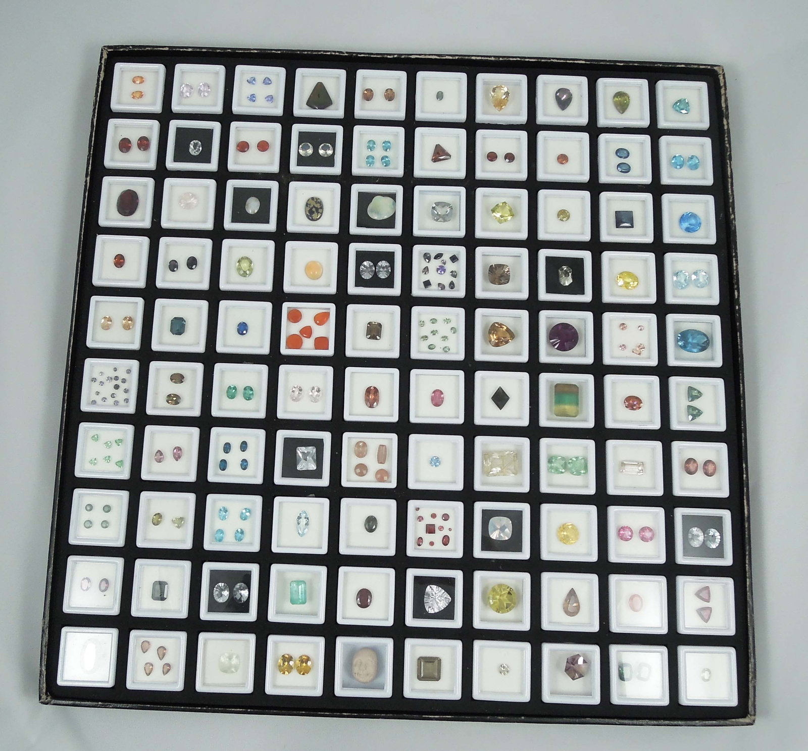 LARGE CASED GROUP OF MANY NATURAL GEMSTONES: Includeing kunsite, citrine, blue topaz, tanzanite, peridot and more. Very few synthetic. Cased set measures 14 1/2" sq. 100's of cts. Of natural gemstones.