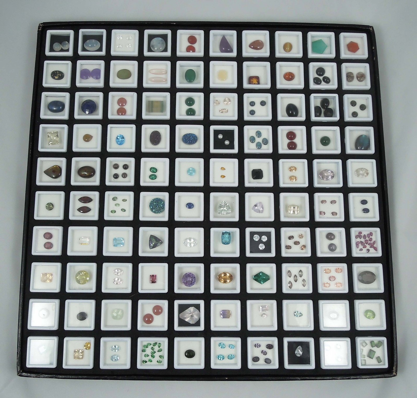 LARGE CASED GROUP OF MANY NATURAL GEMSTONES: Includes quartz, blue topaz, labadorite, peridot, spinel, garnet, pearls, drosy quartz, amber, amethyst and more. 100's of cts. Very few synthetic. Case 14 1/2" sq.
