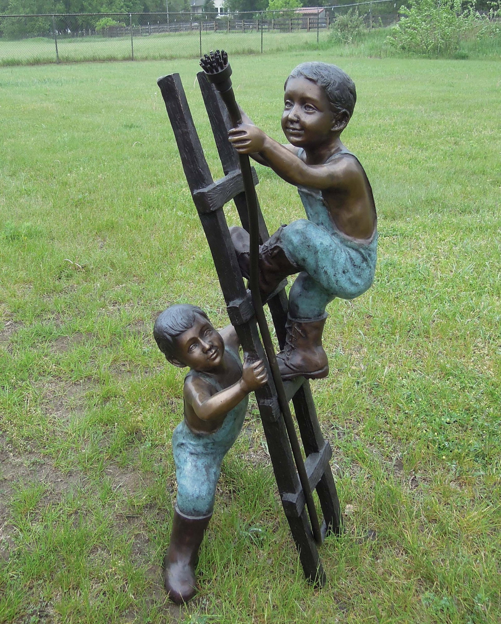 ADORABLE BRONZE SCULPTURE/FOUNTAIN OF TWO CHILDREN ON LADDER: Young boy holds base of ladder while other climbs steps holding fire hose. Water emerges from hose when used as a fountain. Excellent detail. Three color patina. 41" high, 20" wide, 18" deep.