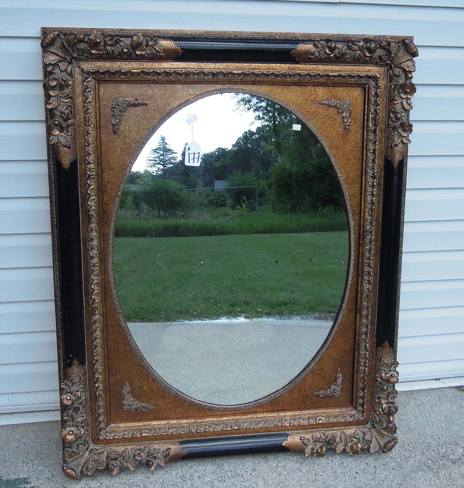 HEAVY CARVED ORNATE BLACK & GILT MIRROR: 51" high, 39 1/2" wide, 3" deep.