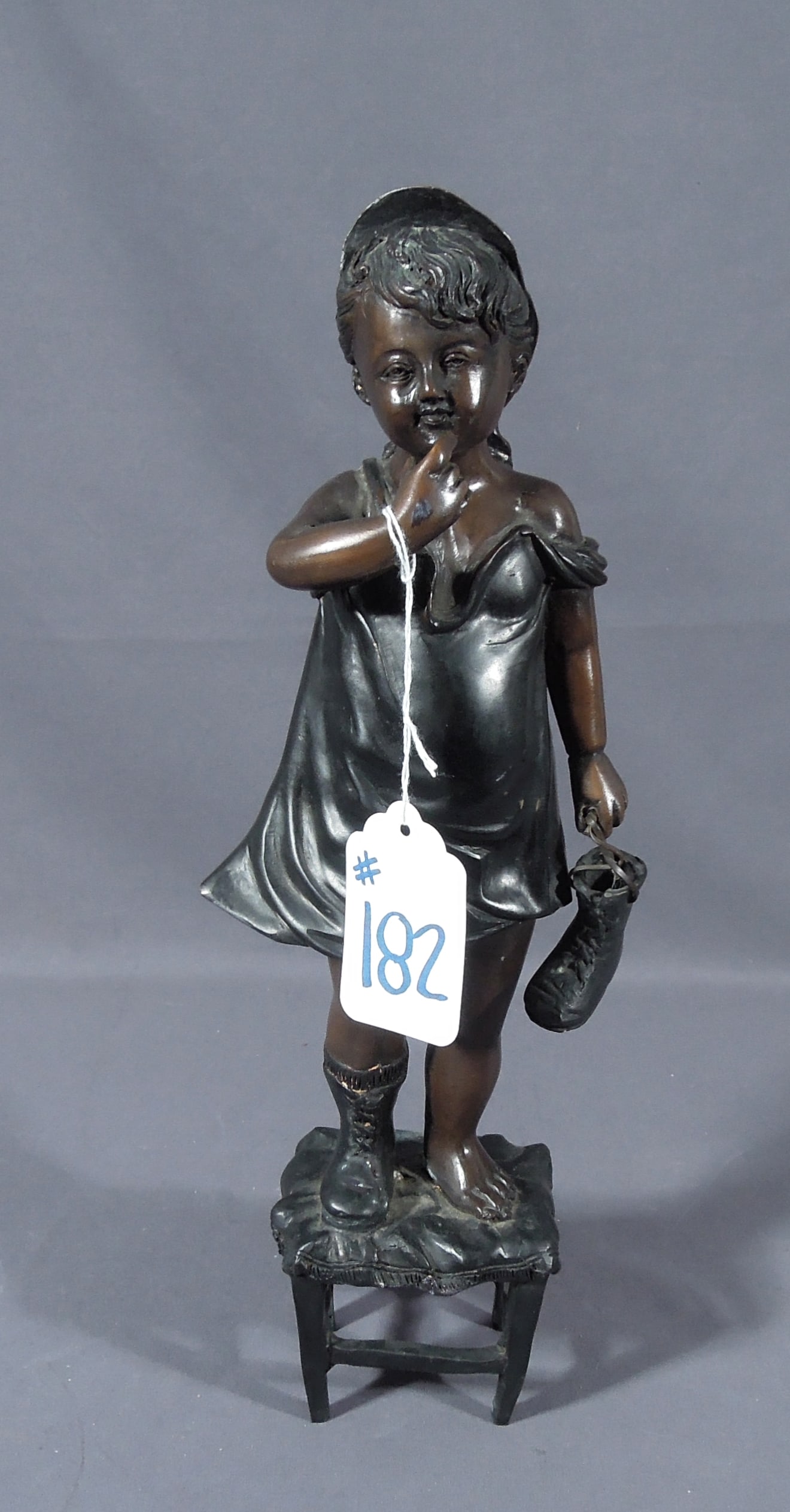 VINTAGE BRONZE SCULPTURE OF YOUNG GIRL STANDING ON STOOL: Aged brown patina. 15 1/2" high.