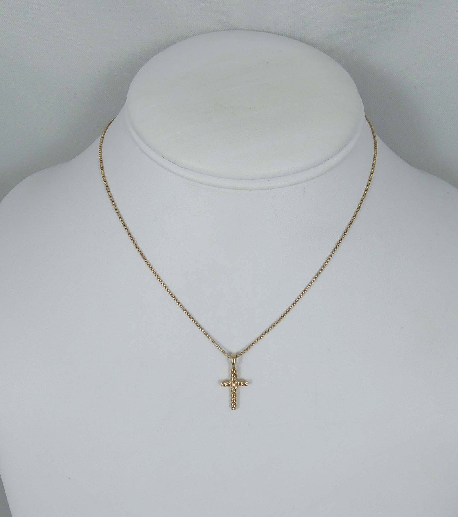DESIGNER DAVID YURMAN 18K Y.G. CHILD'S CROSS NECKLACE: An 18K yellow gold chain supports a small cable 18K cross pendant. Signed DY on clasp with handing charm. Necklace 14" long.