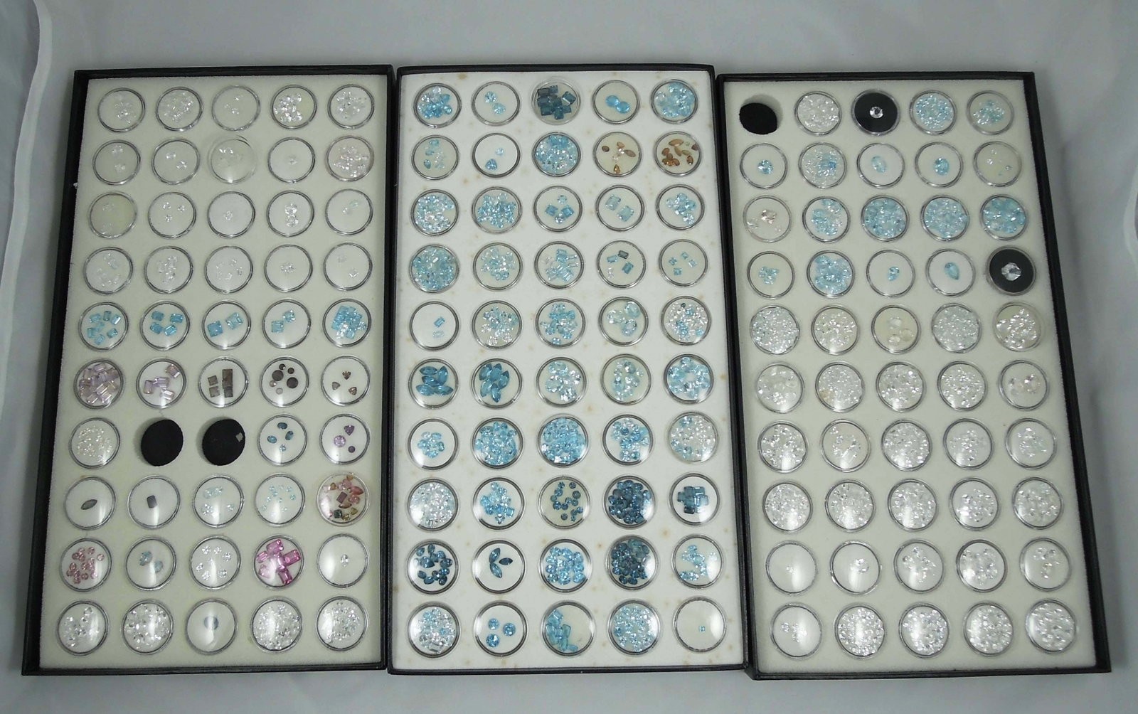 3 CASED BOXES OF NATURAL GEMSTONES: 100's cts. Of natural topaz including white topaz, blue topaz, London blue topaz, amethyst, tourmaline and more.