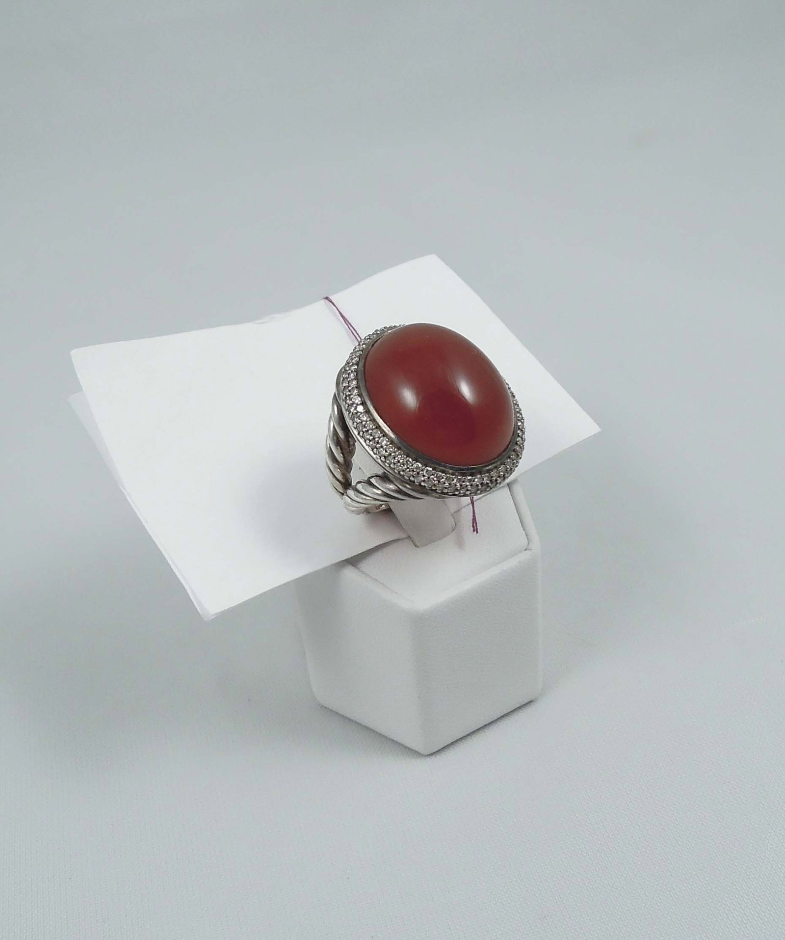 VINTAGE DAVID YURMAN SIGNATURE CARNELIAN & DIAMOND RING: A large cable style ring set with a beautiful cabochon carnelian weighing approx. 25mm x 20mm. Carnelian surrounded by two rows of full cut round diamonds totaling approx. .75. ct. Ring weighs 21.5 gr