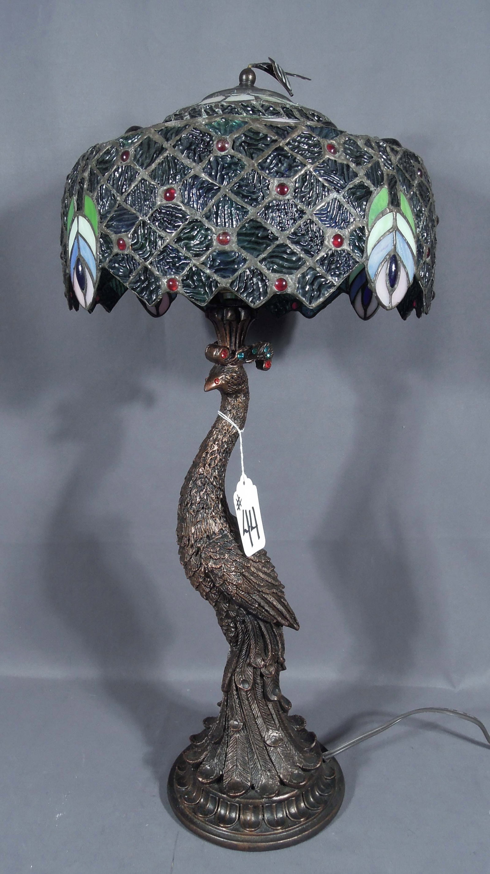 BEAUTIFUL COMPOSITION AND LEADED GLASS PEACOCK TABLE LAMP: A very ornate base with standing peacock supports a beautiful peacock feather leaded glass shade. 26" high, 12" dia.
