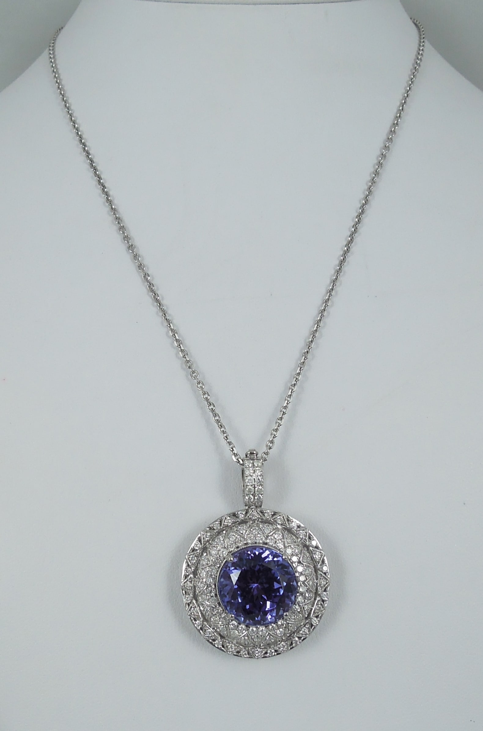 SPECTACULAR LADIES 14K W.G., TANZANITE & DIAMOND NECKLACE: A white gold chain supports a large round pendant set with a heavily faceted fine round cut tanzanite weighing approx. 17.60 cts. Tanzanite surrounded by a row of full cut round diamonds totaling appr