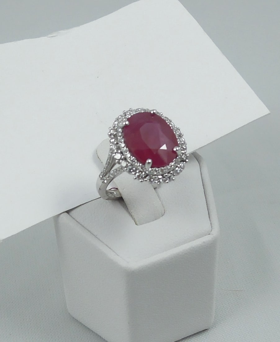 LADIES PLATINUM, BURMESE RUBY & DIAMOND RING: A highly polished platinum mount set with a GIA certified oval Burmese ruby weighing approx. 6 cts. Ruby surrounded by two rows of fine full cut round diamonds totaling approx. .84 cts. Ring complete 