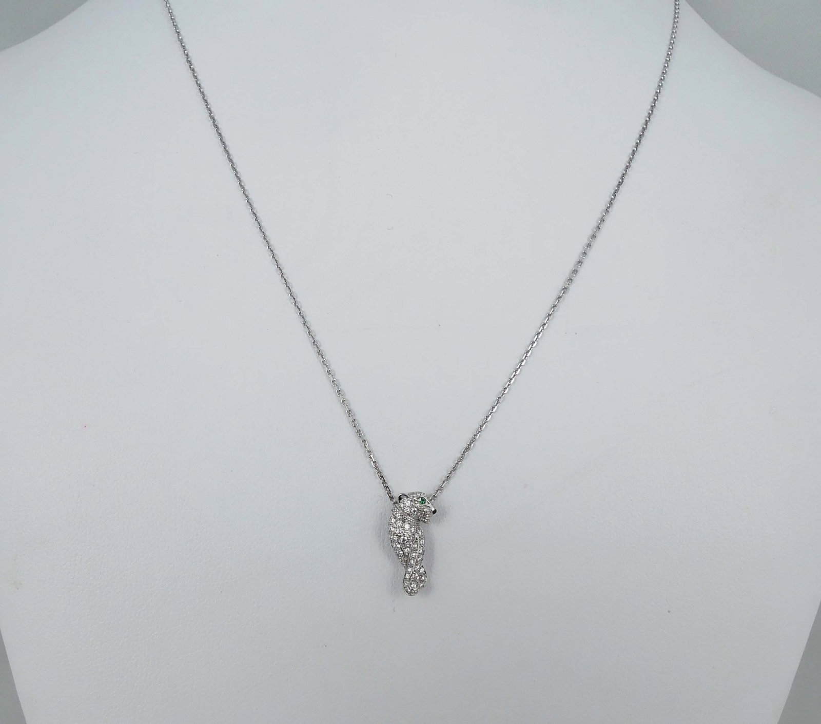 LADIES 18K CARTIER WHITE GOLD, EMERALD & DIAMOND "PANTHER" NECKLACE: Titled "Panthere de Cartier". Signed Cartier 750. Panther encrusted with fine full cut round diamonds totaling .31 ct. and finished with two emerald eyes. Comes with original box and papers with seria