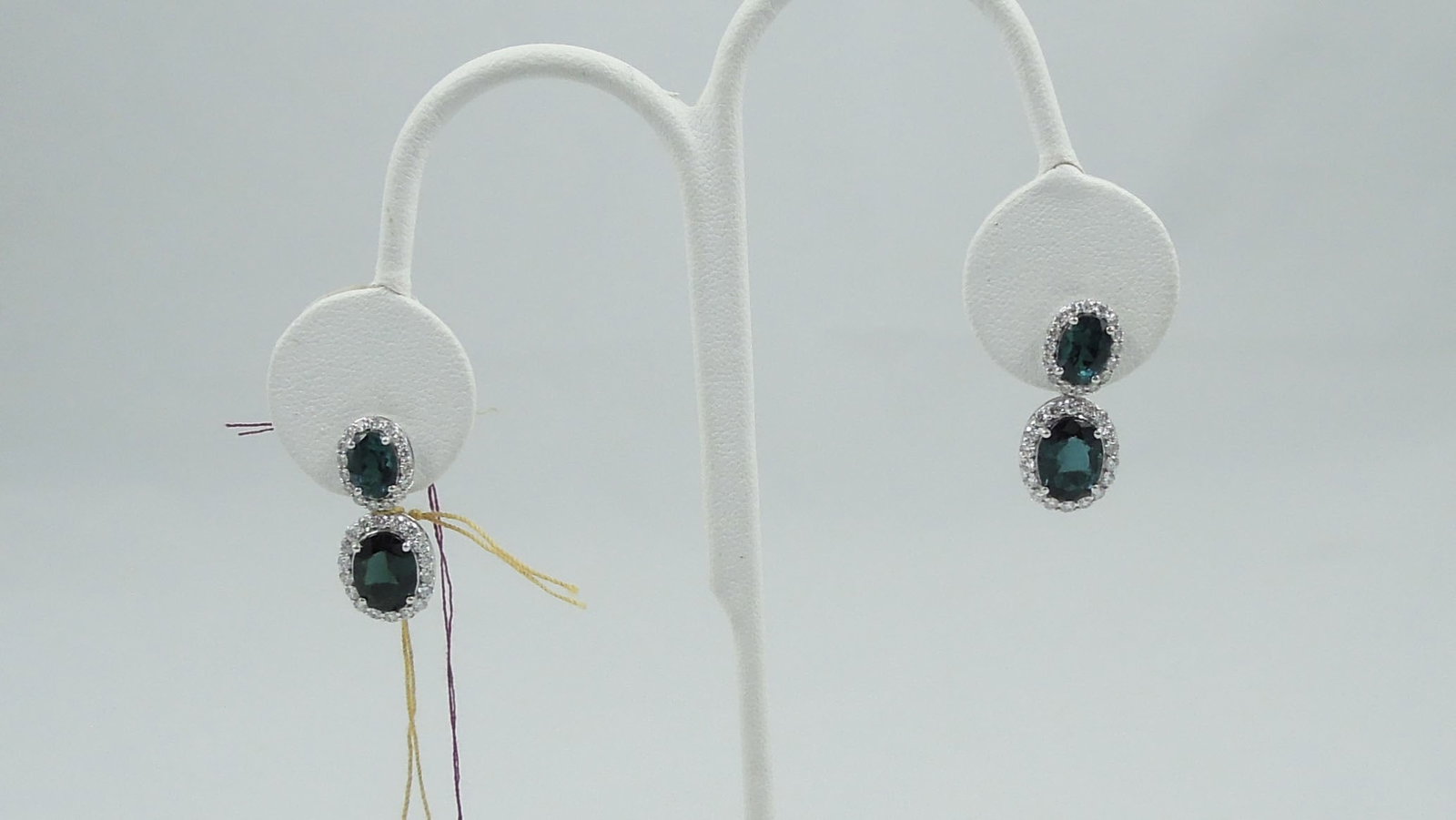 PAIR LADIES PLATINUM, INDICOLITE TOURMALINE & DIAMOND EARRINGS: An oval dangle earring set with a fine oval indicolite tourmaline of blueish/green coloration. Total tourmaline weight approx. 4.84 cts. Tourmaline are surrounded by a single row of full cut round dia