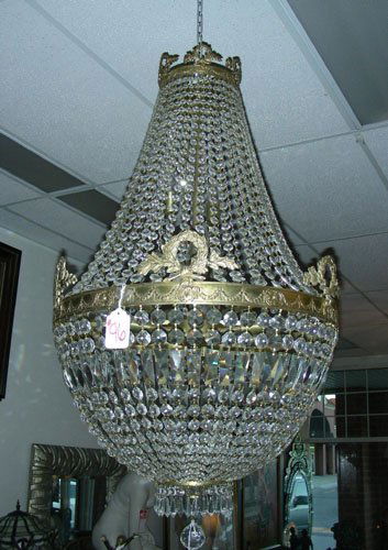 LARGE CRYSTAL AND GILT CHANDELIER: LARGE CRYSTAL AND GILT CHANDELIER A domed shaped chandelier with many strands of crystal beads. Lower section with hanging crystal prisms and a center crystal ball. Metal work with floral motif. 43" h