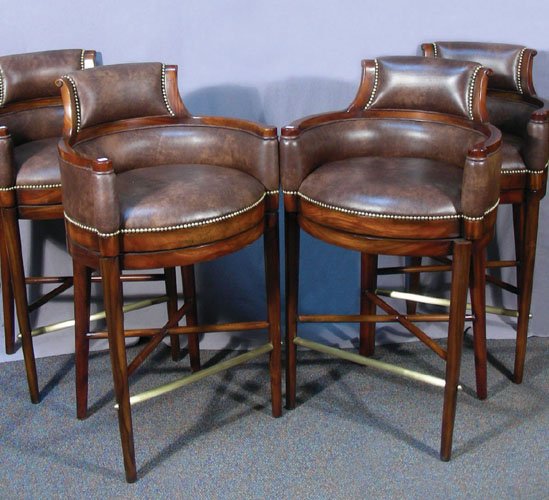 GROUP OF FOUR CARVED WOOD AND LEATHER BAR STOOLS: Very fine quality. Each stool with leather seat and back with brass buttons. Each stool swivels. 45" high.