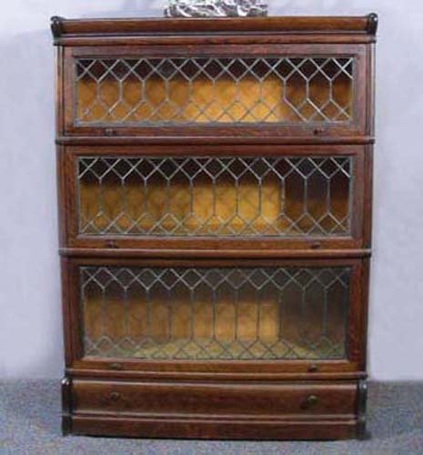 ANTIQUE FRED MACEY AND COMPANY LAWYERS STACK BOOKCASE: A three level bookcase with a lower drawer. Complete with original leaded glass front. 47" high, 34" wide, 12 1/2" deep.