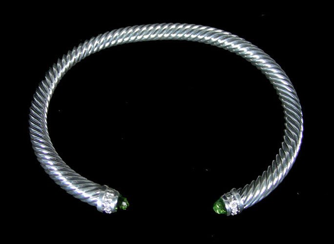 DAVID YURMAN STERLING SILVER, PERIDOT AND DIAMOND CABLE: A heavy sterling silver cable bracelet set on each end with a faceted peridot and rows of full cut round diamonds.