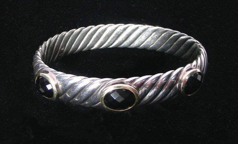 DESIGNER DAVID YURMAN 18K YELLOW GOLD, STERLING & ONYX: A vintage bangle with rib design with three 18K yellow gold sections with faceted oval onyx. Signed.