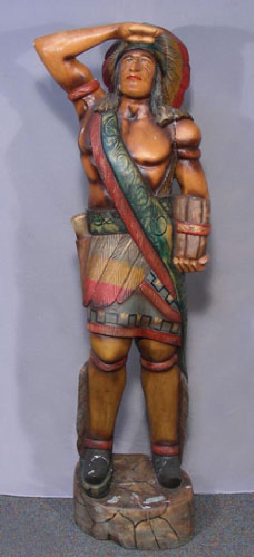 LIFE SIZE HAND PAINTED AND CARVED CIGAR STORE INDIAN: A standing Indian chief in full garb with cigars in one hand and salutes with the other. 6' high.