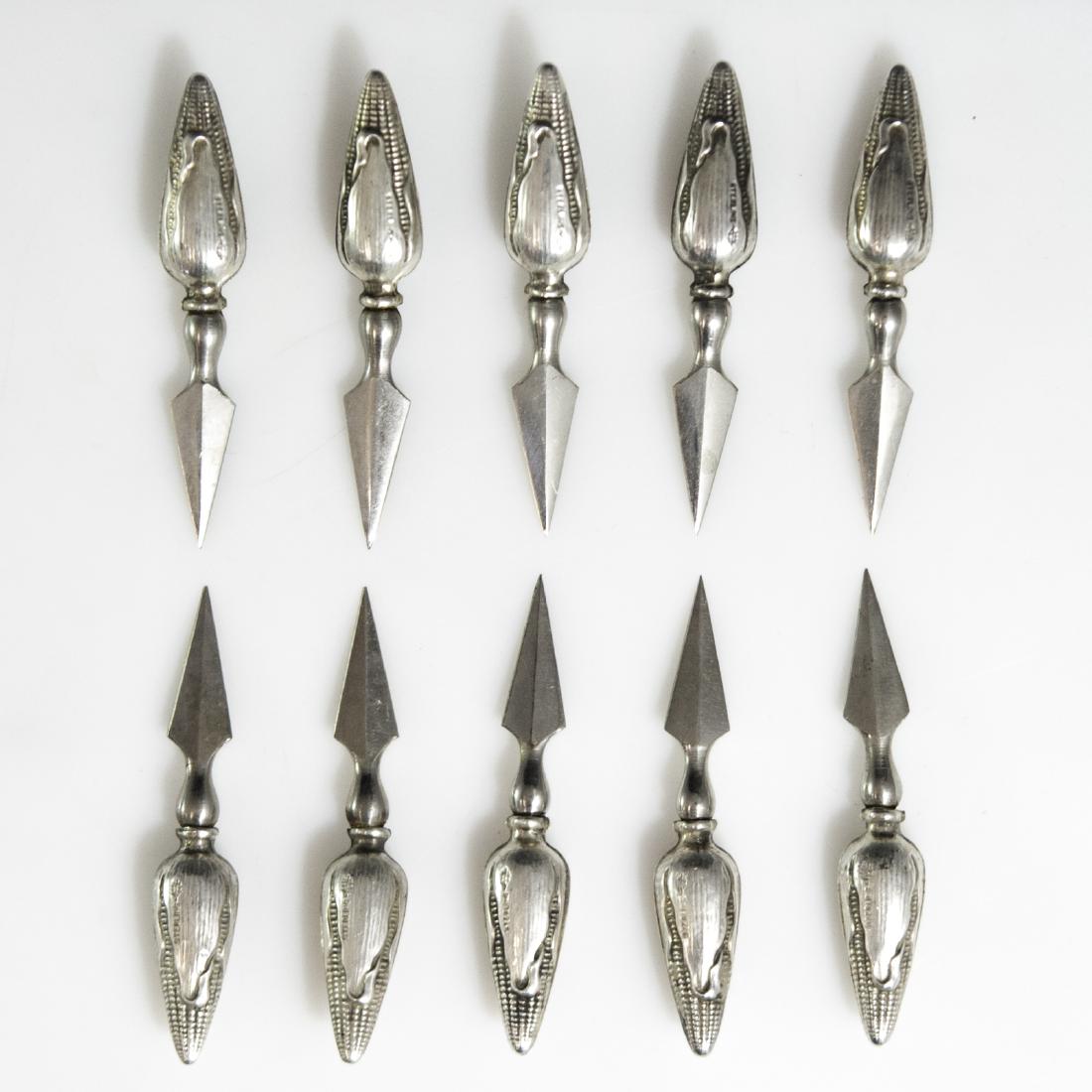 Webster Sterling Corn Picks: DESCRIPTION: A Set of 10 Webster sterling corn picks. Embellished with hollowed sterling handle in the motif of ears of corn. Finished with beveled blades and marked with Webster sterling mark along w