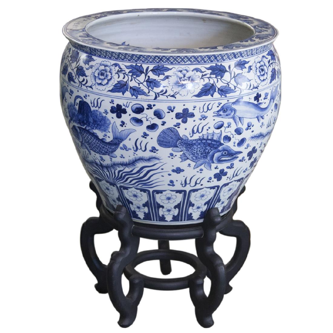 Large Chinese Blue & White Porcelain Fishbowl: DESCRIPTION: A large Chinese porcelain blue and white fishbowl planter. Features a rotund form embellished with blue and white renderings of an array of different swimming fish, enveloped by floral mo