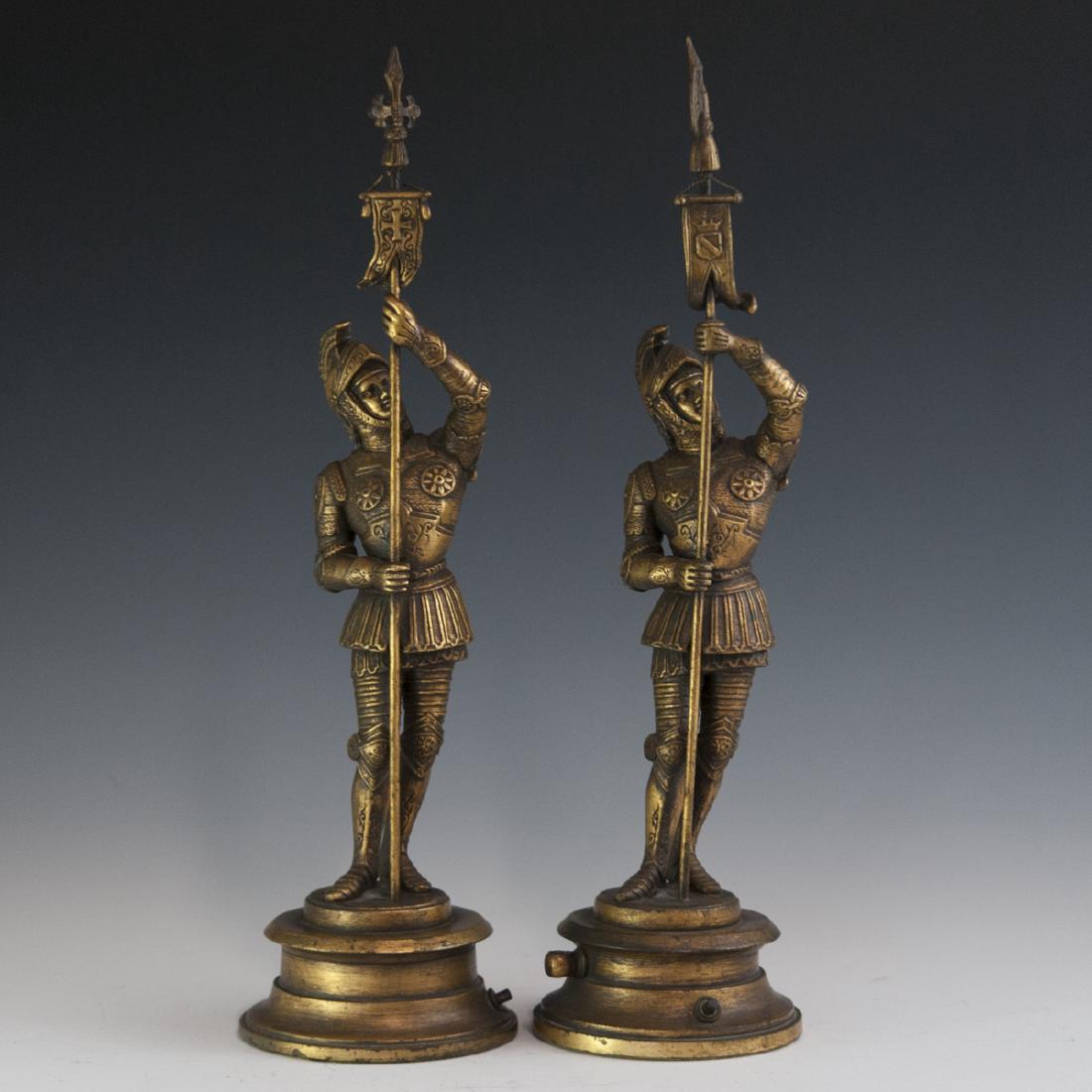 Decorative Gilded Spelter Statues: DESCRIPTION: A pair of gilded spelter statues. Features soldiers wielding crusader banners along their spears as well as regal knight armor. Fitted with switches, indicating they have either been unco