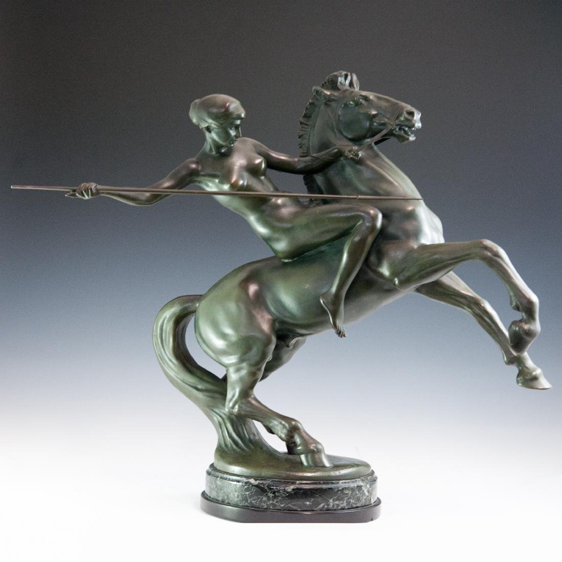 Prof. Anton Grath (Austrian 1881-1956): DESCRIPTION: An Art Deco patinated bronze sculpture by Prof. Anton Grath. Features a nude huntress riding on a rampant horse wielding a spear in her right hand. Finished with an overall green patina a