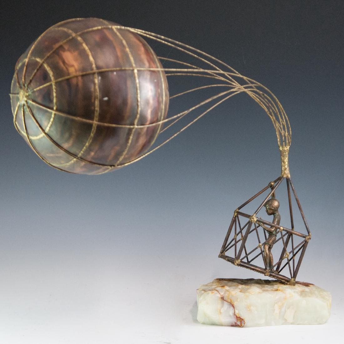 Brian Bijan (20th Ct.): DESCRIPTION: A composite metal sculpture by Brian Bijan. Features a young girl in a basket, wielding a hot air balloon in her hands arching in front of her. Rests atop a rough onyx base. Signed:"Bijan