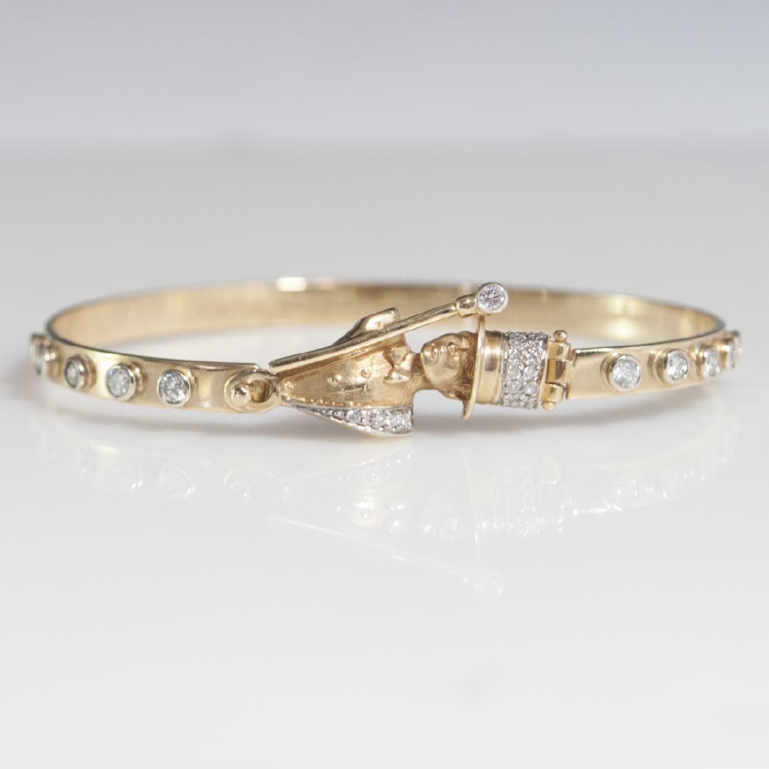 18kt Gold & Diamond Figural Bracelet: DESCRIPTION: An 18kt yellow gold bracelet. Features approximately 1 carat in VS2 H-I color diamonds along the band convening at a Gatsby style gentleman motif clasp wielding a wand and wearing a top h