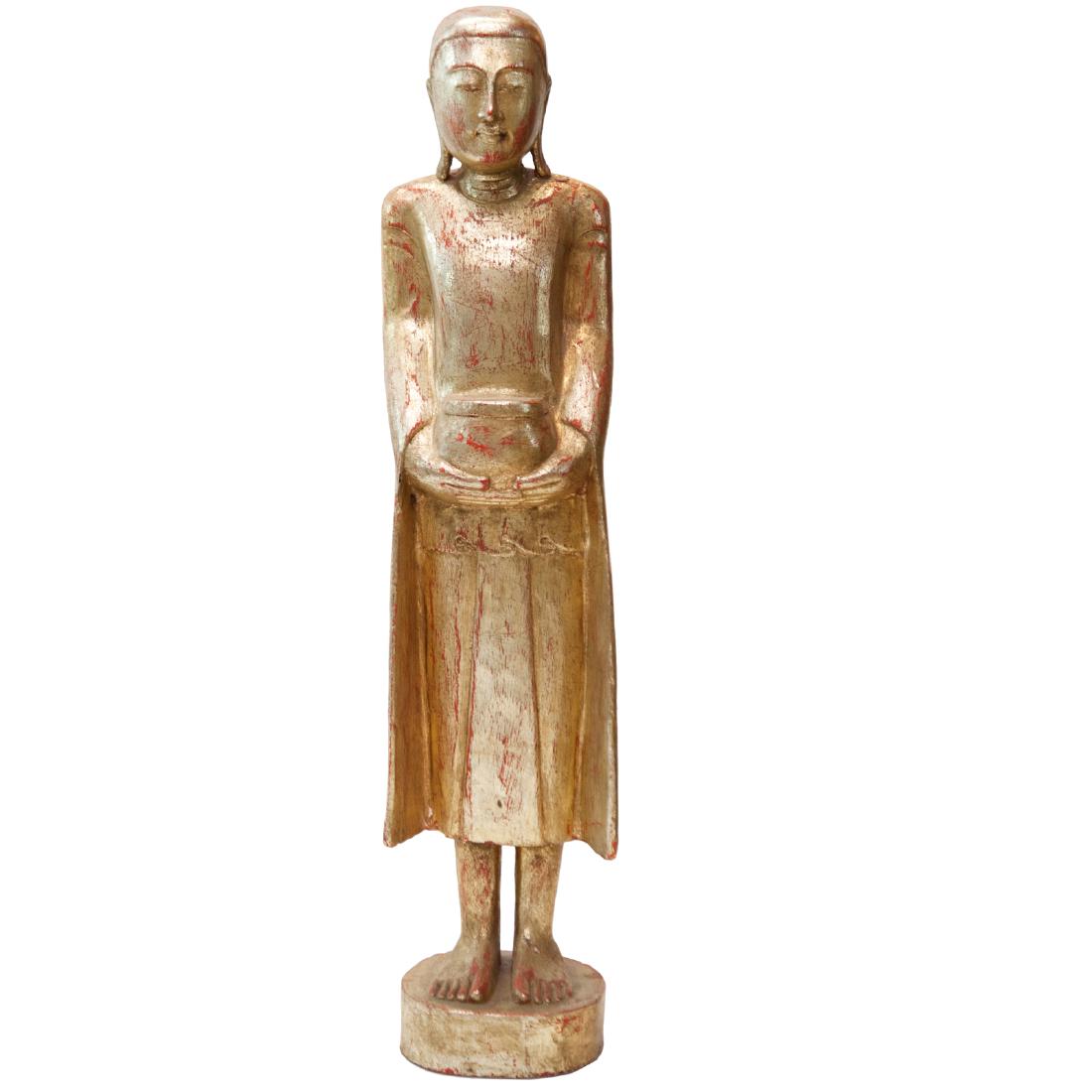 Burmese Gilt Wooden Buddha: DESCRIPTION: An antique Burmese, gilt wooden Buddha, Seen here with elongated ears, wielding a vessel in his hands while his garments flow along side his body. Finished in an overall rich gilt polish.