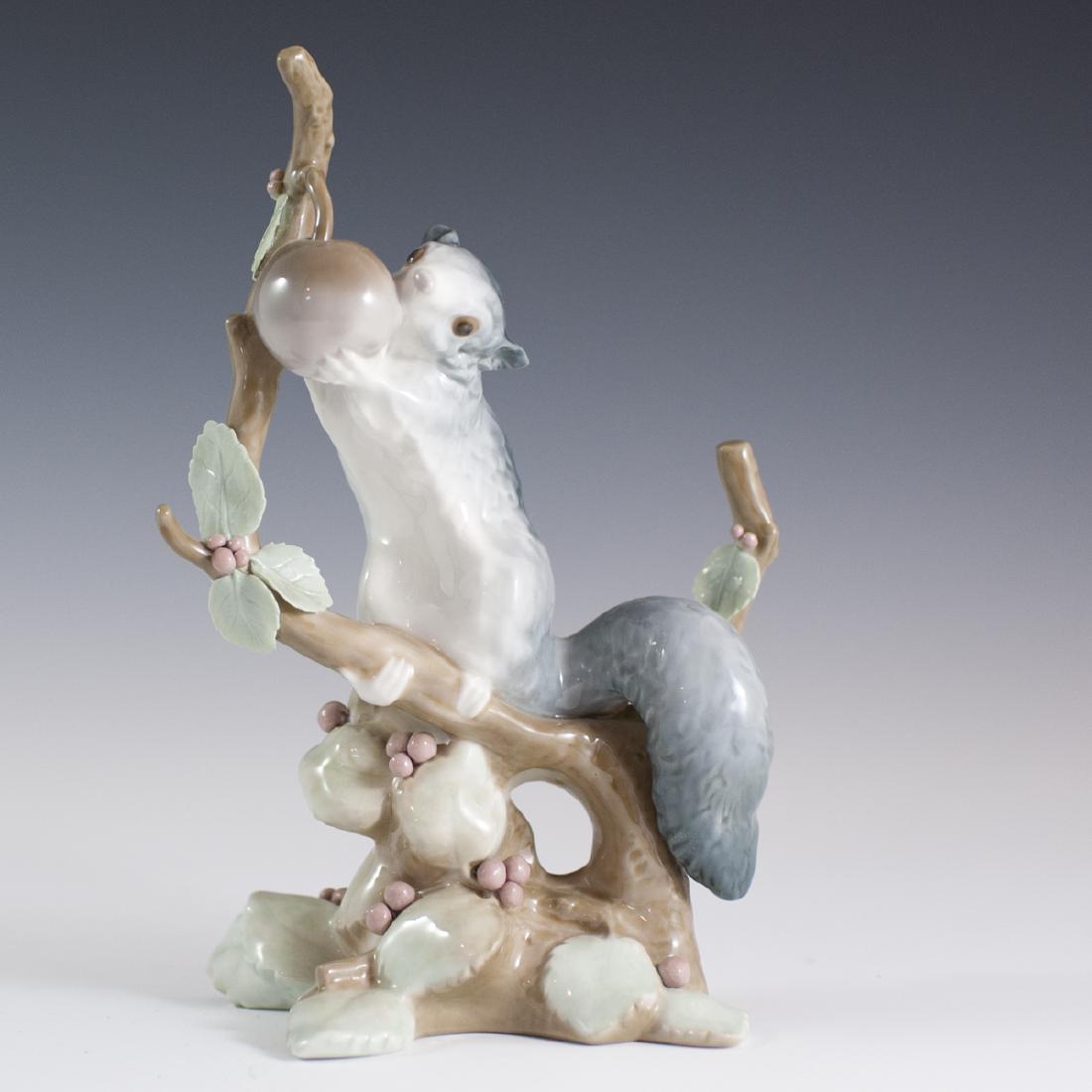 Lladro Porcelain "Dormouse" Figurine: DESCRIPTION: A Lladro porcelain "Dormouse" figurine. Features a squirrel clinging to a tree branch while chewing on a dangling berry along the top of the branch. Finished with an overall glossed glaze