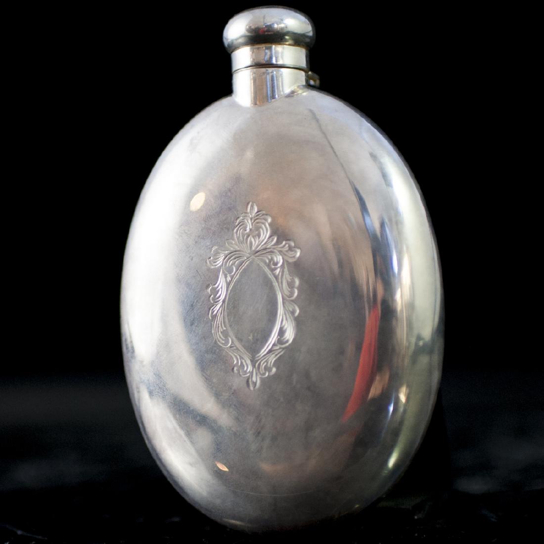 Italian Sterling Flask: DESCRIPTION: A vintage Italian sterling flask. Features an oval form garnished along the center of the body with an engraved Rococo style cartouche. Finished with a twist cap and marked with an Italia