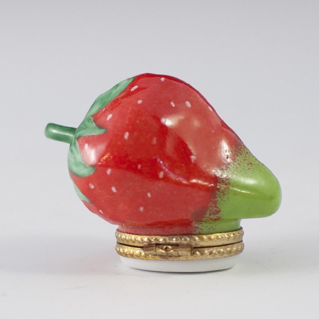 Limoges Porcelain Pill Box: DESCRIPTION: A Limoges porcelain pill box. Features a strawberry along the lid and a gilt metal clasp. Marked:"Limoges France SC Peint Main L.S.". CIRCA: Late 20th Ct. ORIGIN: France DIMENSIONS: H:1 5