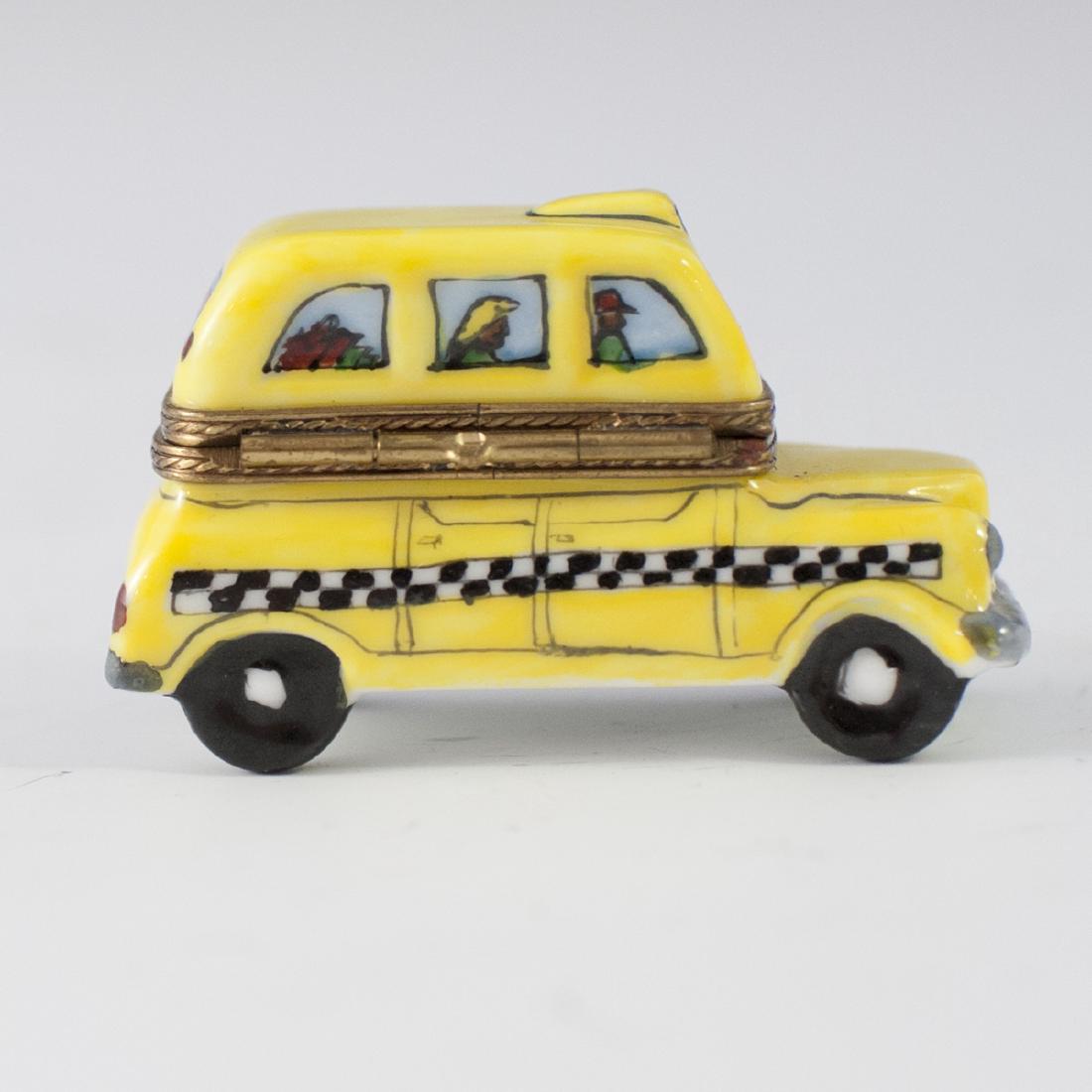 Limoges Porcelain Pill Box: DESCRIPTION: A Limoges porcelain pill box. Features a taxi cab design with figures seen in the windows. Marked along the underside:"Limoges France Peint Main". CIRCA: Late 20th Ct. ORIGIN: France DIME