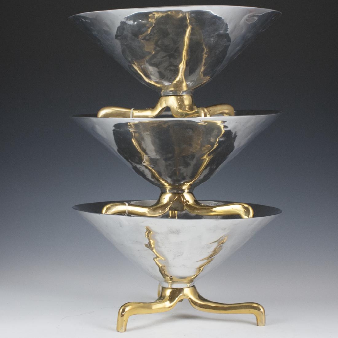 David Marshall Mixed Metal Footed Bowls: DESCRIPTION: A set of three David Marshall footed bowls. Composed of three brass legs, supporting the fluted aluminum bowls with textured detailing. Marked with David Marshall stamps. CIRCA: 20th Ct.
